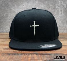 3 Nails Cross Snapback Baseball Cap  A beautiful Design representing such  a beautiful act of Love. Colors : Various  100% Acrylic,  Imported Snap closure Hand Wash Only A High-Profile Cap, With 6 Eyelets  Sits Further Down For a More Fitted Look. Kanye T Shirt, Christian Wishes, Jesus Merch, Christ Centered Wedding, Motivational Clothing, Trendy Hats, Business T Shirt, Christian Hats, Baseball Snapback