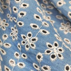 the fabric has sunflowers on it and is blue with white flowers in them