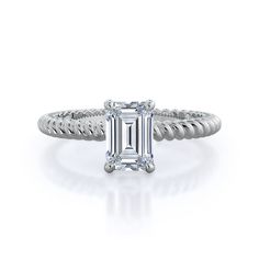 a white gold ring with an emerald cut diamond