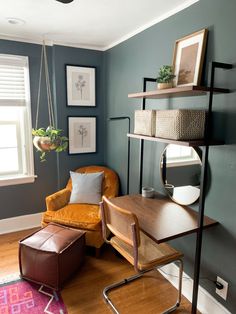 a living room with a chair, desk and shelves on the wall next to a window