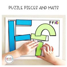 a child's hands on top of a piece of paper with the letter e