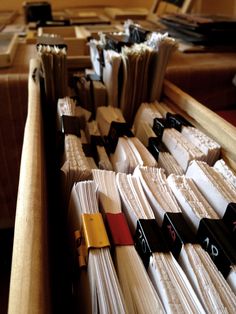 several stacks of folders sitting on top of a table next to each other in a room