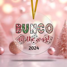 a round ornament with the words bunco all the way in front of christmas trees