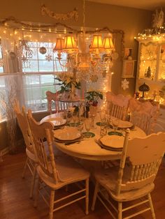 the dining room table is set with white dishes and place settings for four people to eat