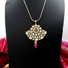 Beautiful high quality ruby kundan pendant and earrings with pave crystal accents. Just the right size - not too big, not too small. Very sparkly and eye-catching. Beautiful meenakari enamel work on reverse of pendant and earrings. This is a substantial, heavy piece. Pendant: Length 3 in. Width 2 1/2 in. Earrings: Length 1 1/2 in. Width 1 3/4 in. Weight 7 gm. Light and comfortable to wear. Shop more amazing necklaces: https://www.etsy.com/shop/boutiquebymaryam/?section_id=32674452 Be sure to vis Traditional Gold Plated Kundan Pendant Necklace, Traditional Gold-plated Kundan Pendant Necklace, Meenakari Pendant Jewelry For Puja, Kundan Temple Jewelry With Round Pendant, Kundan Pendant Necklace With Meenakari, Temple Jewelry With Meenakari Round Pendant, Silver Kundan Necklace With Detachable Pendant For Wedding, Meenakari Temple Jewelry Round Pendant, Meenakari Round Pendant Temple Jewelry