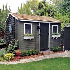 a garden shed with plants and flowers in the window boxes