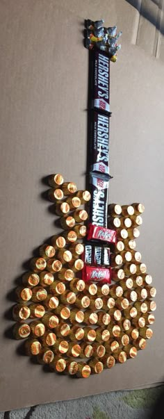 a guitar made out of beer bottle caps and candy bar wrappers on top of it