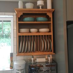 a wooden cabinet filled with dishes in a kitchen