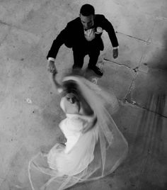 a bride and groom are dancing on the floor in black and white, from above