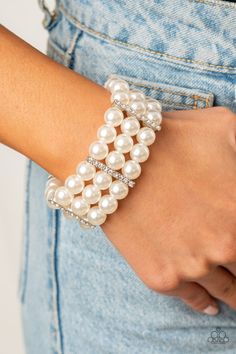 Held together by white rhinestone dotted silver fittings, row after row of bubbly white pearls are threaded along stretchy bands around the wrist for a timeless elegance.

 Sold as one individual bracelet. White Pearl Bracelet, Beads Bracelet Design, White Bracelets, Paparazzi Accessories, Stretchy Bracelets, White Rhinestone, Paparazzi Jewelry, Jewelry Business, Boutique Jewelry