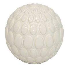 a white ball with circles on it is sitting in front of a white wallpaper