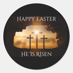 a round sticker with two crosses and the words happy easter he is risen on it