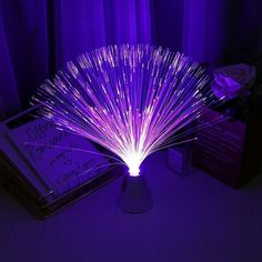 a purple light that is sitting on top of a table in front of a book