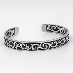 This cuff bracelet represents Balinese silversmith artistry at its finest. On the outside of the band is an intricately carved Balinese tribal motif. Traditional scroll work continues through the underside of the band, creating a bracelet that's impressive on both the inside and out. Metal: 925 Sterling Silver Sizes: Small; Large Artisan Cuff Bracelet With Intricate Adjustable Design, Artisan Adjustable Cuff Bracelet With Intricate Design, Adjustable Carved Cuff Bangle Bracelet, Adjustable Carved Cuff Bangle, Antique Silver Adjustable Bangle With Intricate Design, Adjustable Antique Silver Bangle With Intricate Design, Antique Silver Etched Cuff Bangle, Antique Silver Adjustable Cuff Bracelet With Intricate Design, Adjustable Antique Silver Cuff Bracelet With Intricate Design