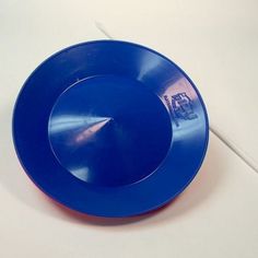 a blue plate sitting on top of a white table next to a red and white cord