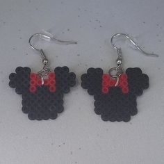 a pair of mickey mouse earrings with red and black beads hanging from silver earwires