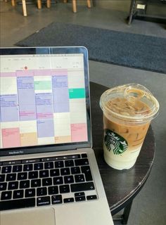 a laptop computer sitting on top of a table next to a cup of coffee