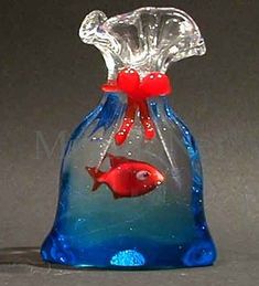 a glass vase with two red fish in it's mouth and blue water inside