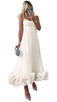 a woman in a white dress taking a selfie with her cell phone and purse