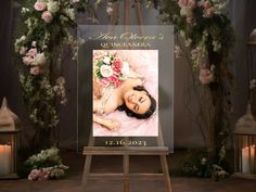 an easel with a photo of a woman on it in front of flowers and candles