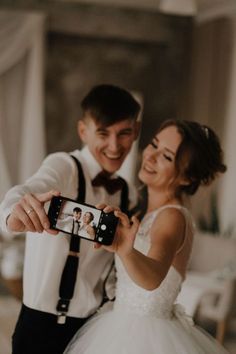 a bride and groom taking a selfie with their cell phone in front of them