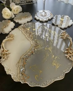 a table topped with lots of glass plates and vases on top of a wooden table