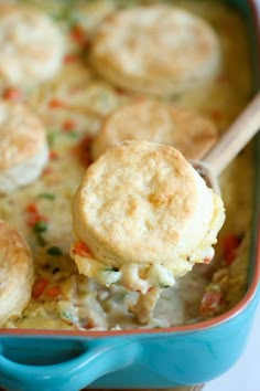 a spoon full of chicken pot pie casserole being lifted from the casserole dish