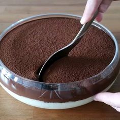 a person cutting into a chocolate cake with a knife