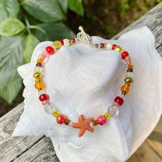 Colorful boho bracelet with an orange metal starfish focal bead, accented with a variety of smaller beads in orange/red colors. Bracelet is 6.5 inches long - please let me know if you need a different length and I will adjust it Starfish Shaped Beaded Bracelets For Beach, Colorful Beaded Starfish Bracelets For Beach, Colorful Starfish Beaded Bracelets For Beach, Orange Beach Bracelets With Spacer Beads, Bohemian Beaded Bracelet With Starfish For Beach Season, Bohemian Starfish Beaded Bracelet For Beach Season, Bohemian Beaded Bracelets With Starfish Charm For Beach, Starfish Shaped Beaded Bracelets For Beach Season, Colorful Beads Starfish Bracelet For Vacation