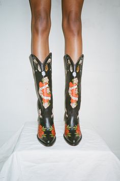 The Brother Vellies Doodle Boots have been a long-time fan favorite. They are one-of-a-kind works of art handmade and hand painted with love by Artisans in Mexico. In honor of Women’s History Month, Brother Vellies is releasing a limited collection of custom Doodles, featuring three new Doodle Boots and two new Doodl Cowboy Boots And Bathing Suits, Brother Vellies Shoes, Custom Made Cowboy Boots, Art On Clothes Paint, Aurora James, Eccentric Shoes, Brother Vellies, Cowboy Aesthetic, Black Cowgirl