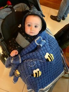 a small child in a blue crocheted blanket