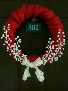 a red wreath with white flowers on it