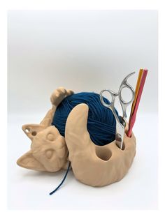 a crochet hook with scissors, yarn and knitting needles in the shape of a rhinoceros