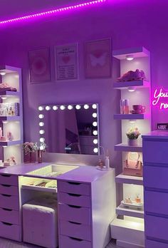 a purple vanity with lights and drawers in a room that is lit up at night