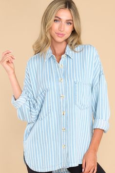 This blue top features a collared neckline, functional buttons down the front, two functional bust pockets, long sleeves with buttoned cuffs, a scoop bottom hem, and a super soft material. Blue Tops With Roll-up Sleeves For Daywear, Blue Tops With Roll-up Sleeves For Spring, Blue Tops With Roll-up Sleeves For Everyday, Blue Collared Top With Roll-up Sleeves, Oversized Blue Top With Placket, Blue Casual Tops With Roll-up Sleeves, Light Blue Casual Top With Placket, Casual Blue Tops With Roll-up Sleeves, Blue Relaxed Fit Top With Button Closure