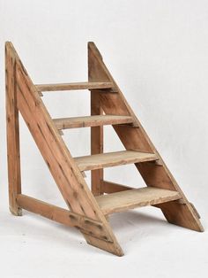 a wooden shelf with three shelves on each side and two steps down the middle, against a white background