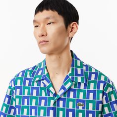 Enjoy 100% croco-style in this archive-inspired shirt, featuring a bold print designed by Lacoste logo creator Robert George. With genuine mother-of-pearl buttons for a chic, hip feel. Collared Tops With Logo Print For Summer, Summer Collared Tops With Logo Print, Summer Collared Top With Logo Print, Casual Shirt With Graphic Print And Spread Collar, Designer Graphic Print Button-up Tops, Casual Printed Top With Spread Collar, Green Logo Print Shirt For Summer, Green Logo Print Summer Shirt, Retro Summer Shirt With Logo Print