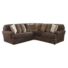 a brown sectional couch with pillows on it's back and side facing each other