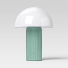 a green and white table lamp on a gray background