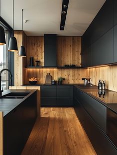 a kitchen with black cabinets and wooden floors is seen in this image from the side