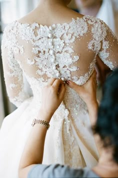 a woman in a wedding dress getting ready