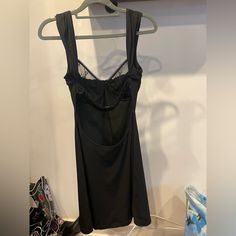 a black dress hanging up on a hanger