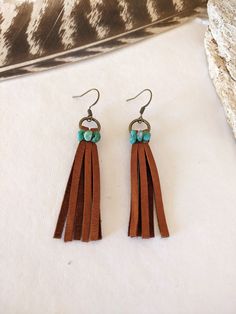 Brown Leather Fringe and Genuine Turquoise Earrings Brown leather fringe hangs from a antique brass ring and is wire-wrapped with genuine Campitos turquoise mined in Sonora, Mexico. Length is approximately 2.75 in. long (including ear wire). Earring hangs from a french-style ear wire. Shop all of our earrings HERE: https://etsy.me/3DFs84O Please let me know if you have any questions! All jewelry creations are handmade by myself in my smoke-free Arizona studio.  I can't wait to welcome you to the Brown Tassel Earrings For Festivals, Brown Bohemian Tassel Earrings, Bohemian Brown Tassel Earrings, Bohemian Brown Fringe Earrings, Brown Fringe Dangle Jewelry, Adjustable Brown Bohemian Tassel Earrings, Artisan Dangle Fringe Jewelry, Artisan Fringe Dangle Jewelry, Brown Dangle Jewelry For Festival