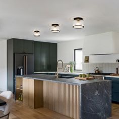 a kitchen with marble counter tops and wooden floors