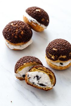 chocolate and white cream filled donuts on a marble surface