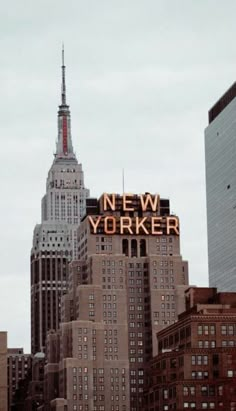 the new york sign is lit up on top of buildings