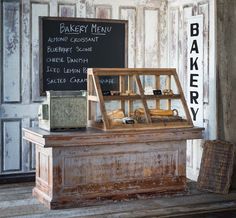 an old bakery display in front of a chalkboard