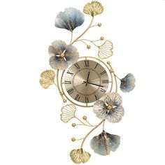 a gold clock with blue flowers and leaves on the face is shown against a white background