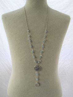 "This one of a kind necklace is made of beautiful faceted Aquamarine, Swarovski crystals and large silver plated medallion.  A silver-plated chain and lobster claw clasp complete the look.  The necklace is 37\" long to the top of the medallion; the drop (including medallion) is 4.5\" long." Silver Necklaces With Round Pendant And Beaded Chain, Silver Long Medallion Necklace, Bohemian Silver Crystal Necklace With Round Pendant, Silver Pendant Crystal Necklace With Lobster Clasp, Crystal Long Necklaces With Adjustable Chain, Crystal Long Necklace With Adjustable Chain, Silver Beaded Round Pendant Jewelry, Silver Metal Crystal Necklace With Lobster Clasp, Silver Metal Lariat Necklace With Lobster Clasp