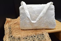 Looking for the perfect accessory to complete your wedding look? Look no further than this white lace bridal bag with a handle! Crafted from high-quality lace, this stunning bridal bag is sure to turn heads on your special day. With its delicate white lace design and elegant handle, it's the perfect addition to any bridal outfit. Not only is this bag beautiful, but it's also practical. It's the perfect size for carrying your essentials on your wedding day, such as your phone, makeup, and other s White Handheld Shoulder Bag For Wedding, Elegant Cream Bag For Ceremony, Elegant Cream Bag For Ceremonies, White Wedding Bag With Pearl Handle, White Bags With Pearl Handle For Wedding, White Clutch Bag For Wedding Guests, Elegant Bridal Accessories With Lace Work For Ceremony, Elegant Lace Bridal Accessories For Evening, White Handheld Evening Bag For Wedding